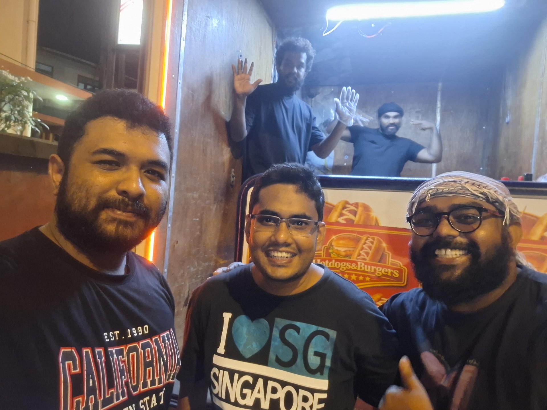 Customers and brothers at the food truck at night